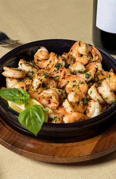 a bowl of shrimp with lemon and basil