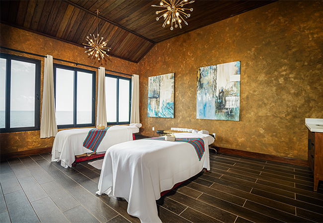 a room with two beds and paintings on the wall