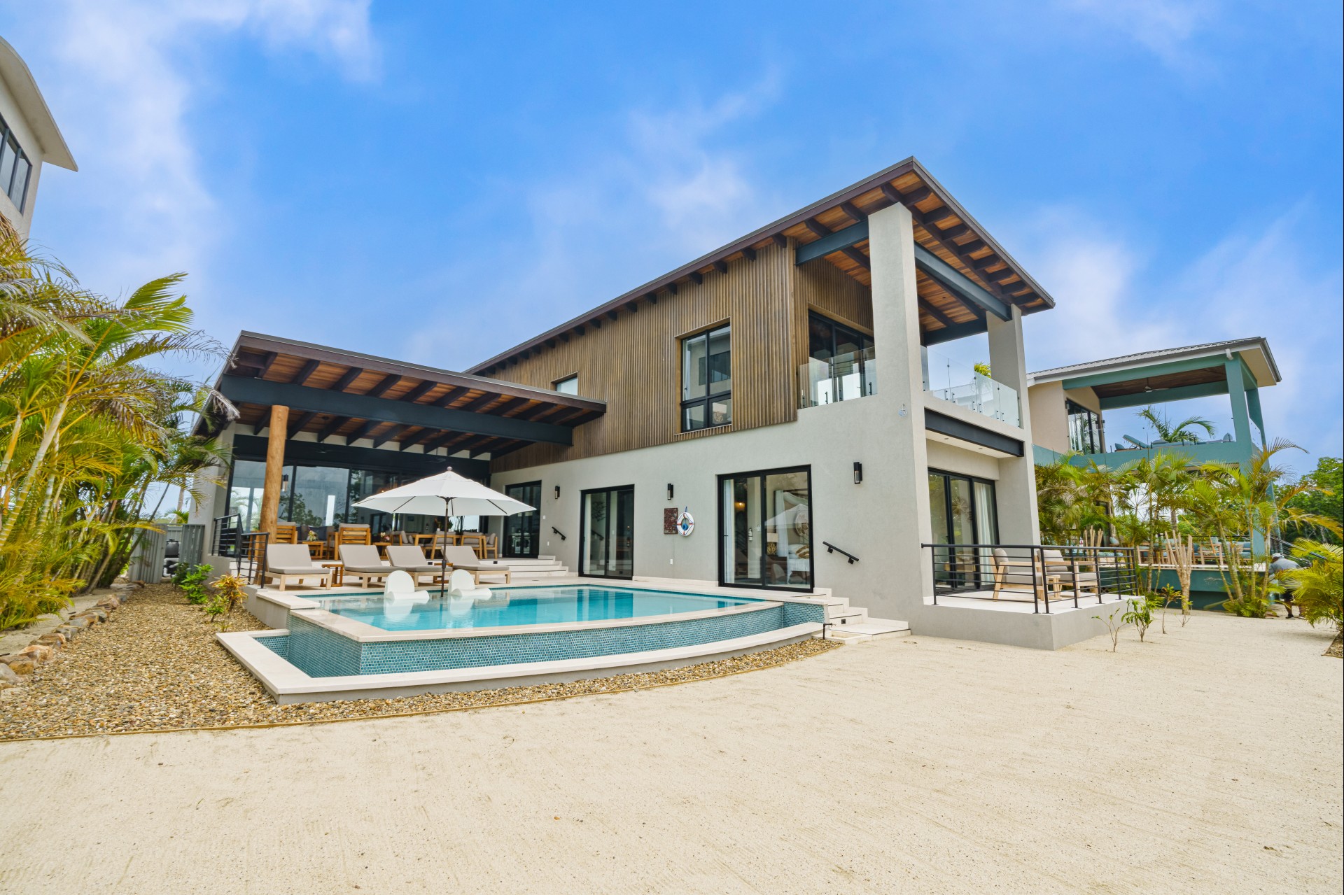 a house with a pool and umbrellas