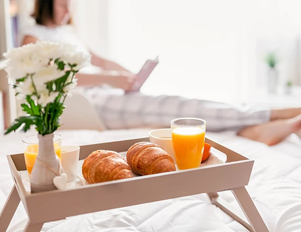 close up view to a picnic table with croissants and a glass of orange juice
