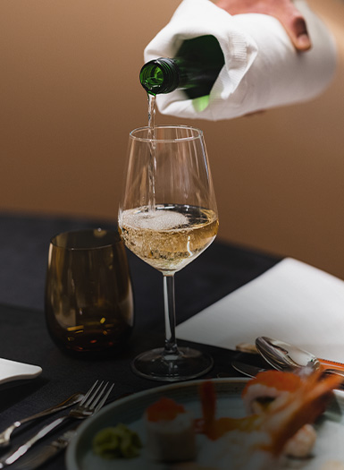 someone pouring a glass of wine