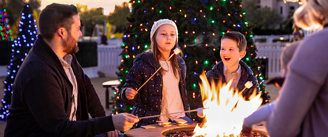 a family with their kids by the fireplace