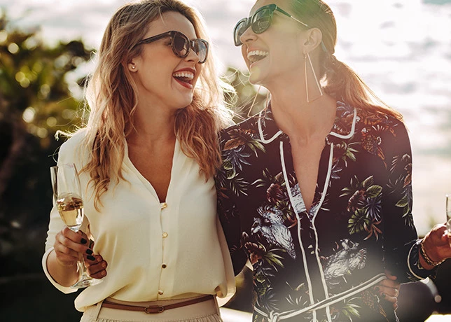 two women laughing with their champagne glasses