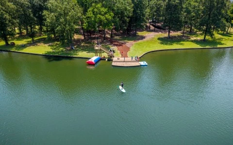 a aerial view of a lake with a dock and people on it