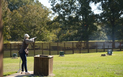 a woman shooting a gun at a target