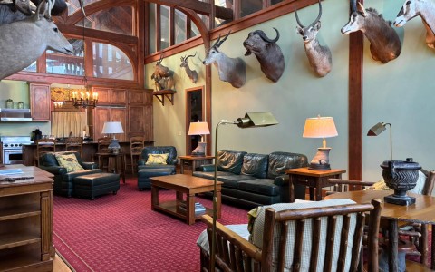 a room with a large wall with a couch and chairs and a lamp