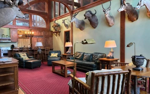 a room with a large wall with a couch and chairs and a lamp