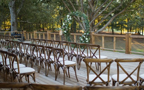 chairs on a deck with trees in the background