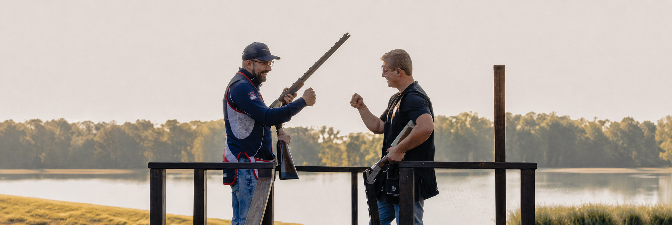 two men holding guns and standing next to each other