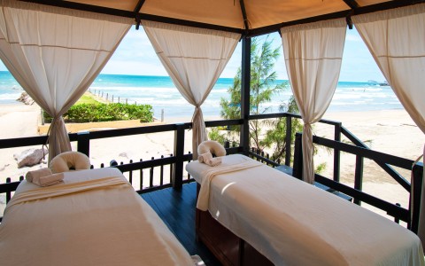 massage beds on a deck with a beach view