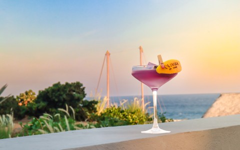 a glass of purple liquid with a yellow label on top of it