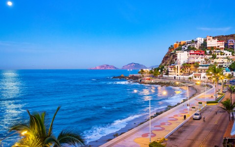 a beach with buildings and a body of water
