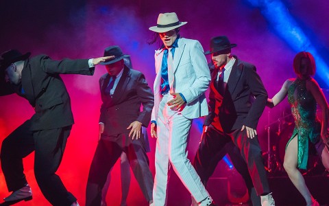 a group of men wearing hats and dancing on a stage