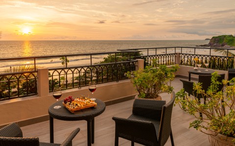 a table and chairs on a deck overlooking the ocean