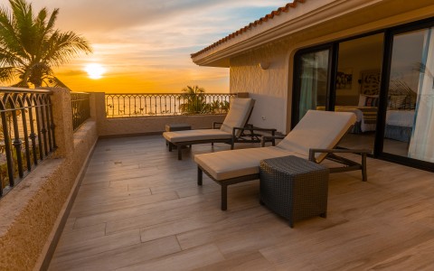 a deck with chairs and a sunset