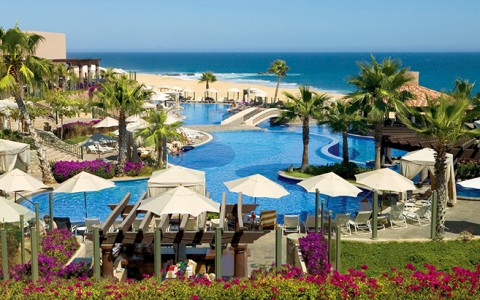 a pool with umbrellas and chairs and palm trees
