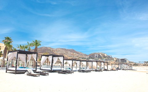 a beach with chairs and a canopy