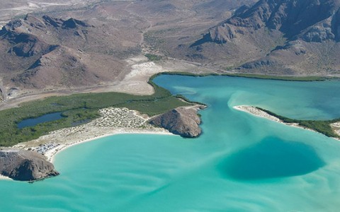 a blue water and mountains