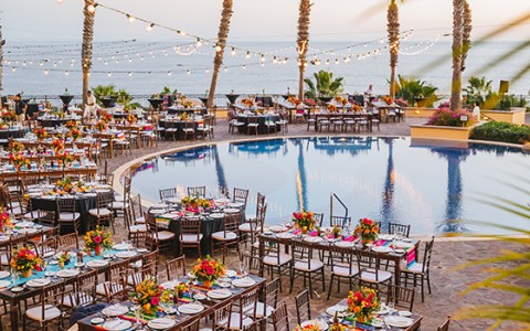 a pool with tables and chairs and flowers
