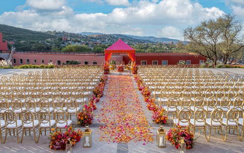 a wedding ceremony with chairs and flowers