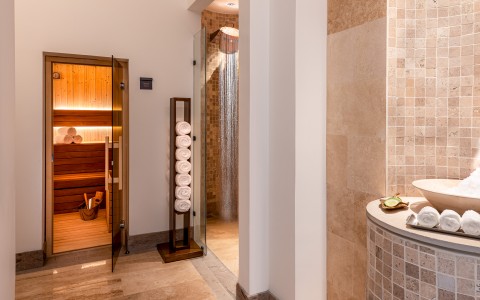 a bathroom with a glass shower door and a towel rack