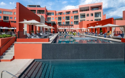 a pool and a building with umbrellas