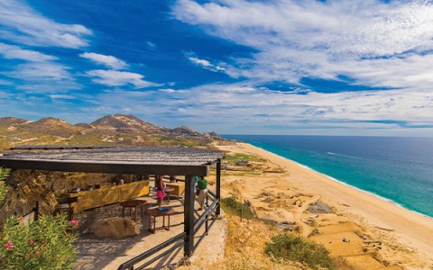 a beach with a wooden structure and a body of water