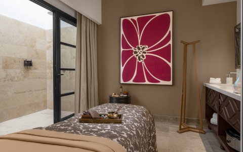 a bed with a pink flower on it