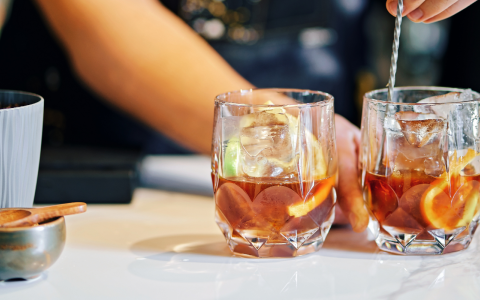 two glasses with brown liquid and ice