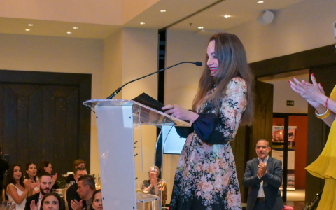 a woman standing at a podium with a microphone