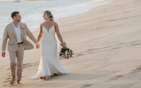 a man and woman walking on a beach