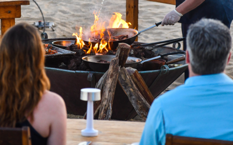 a group of people at a table with food on fire