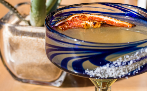 a glass with liquid and a slice of orange in it