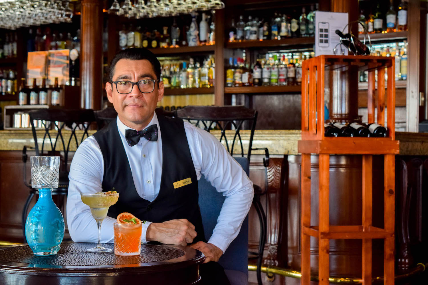 a man sitting at a table with drinks