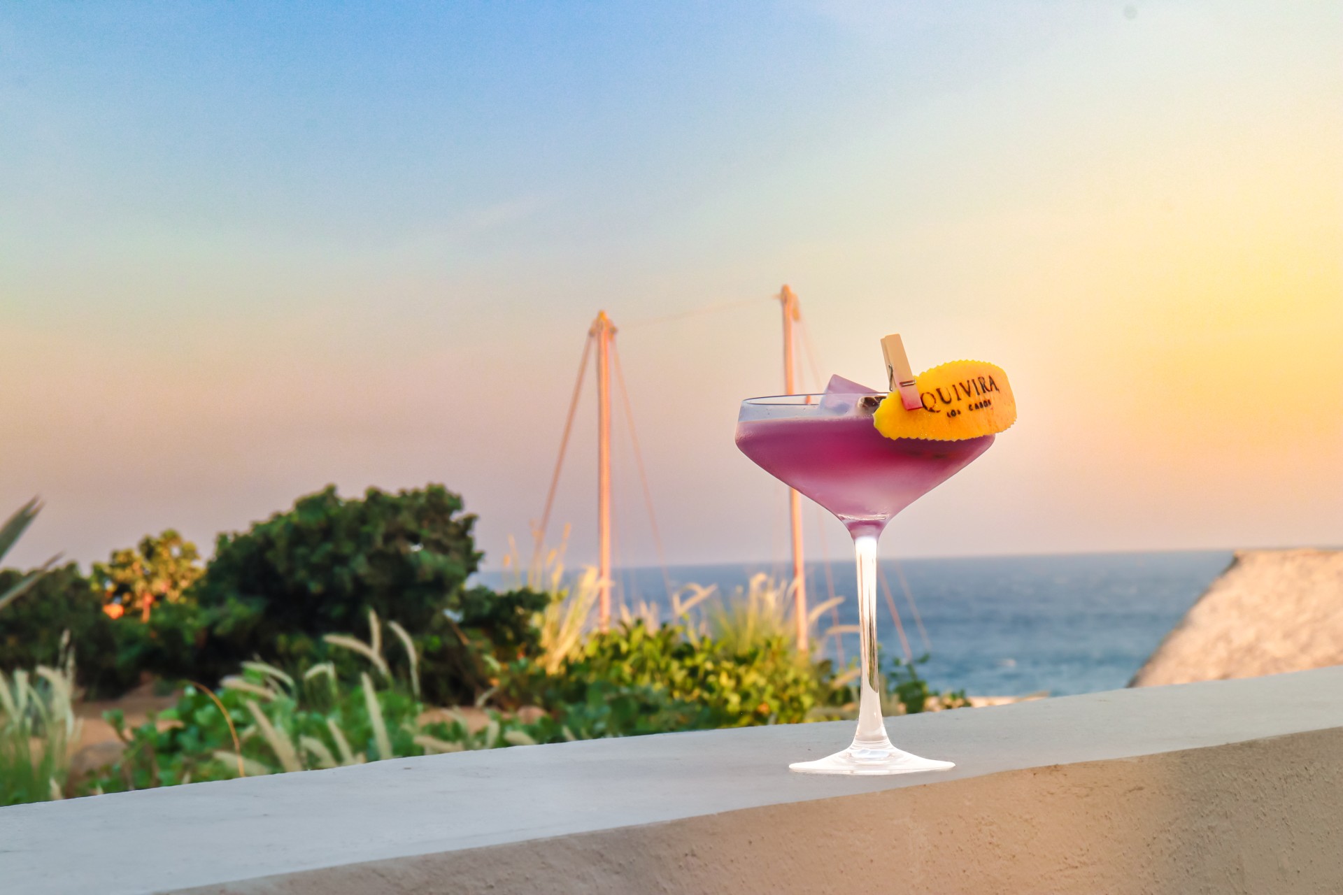 a glass of purple liquid with a yellow label on top of it