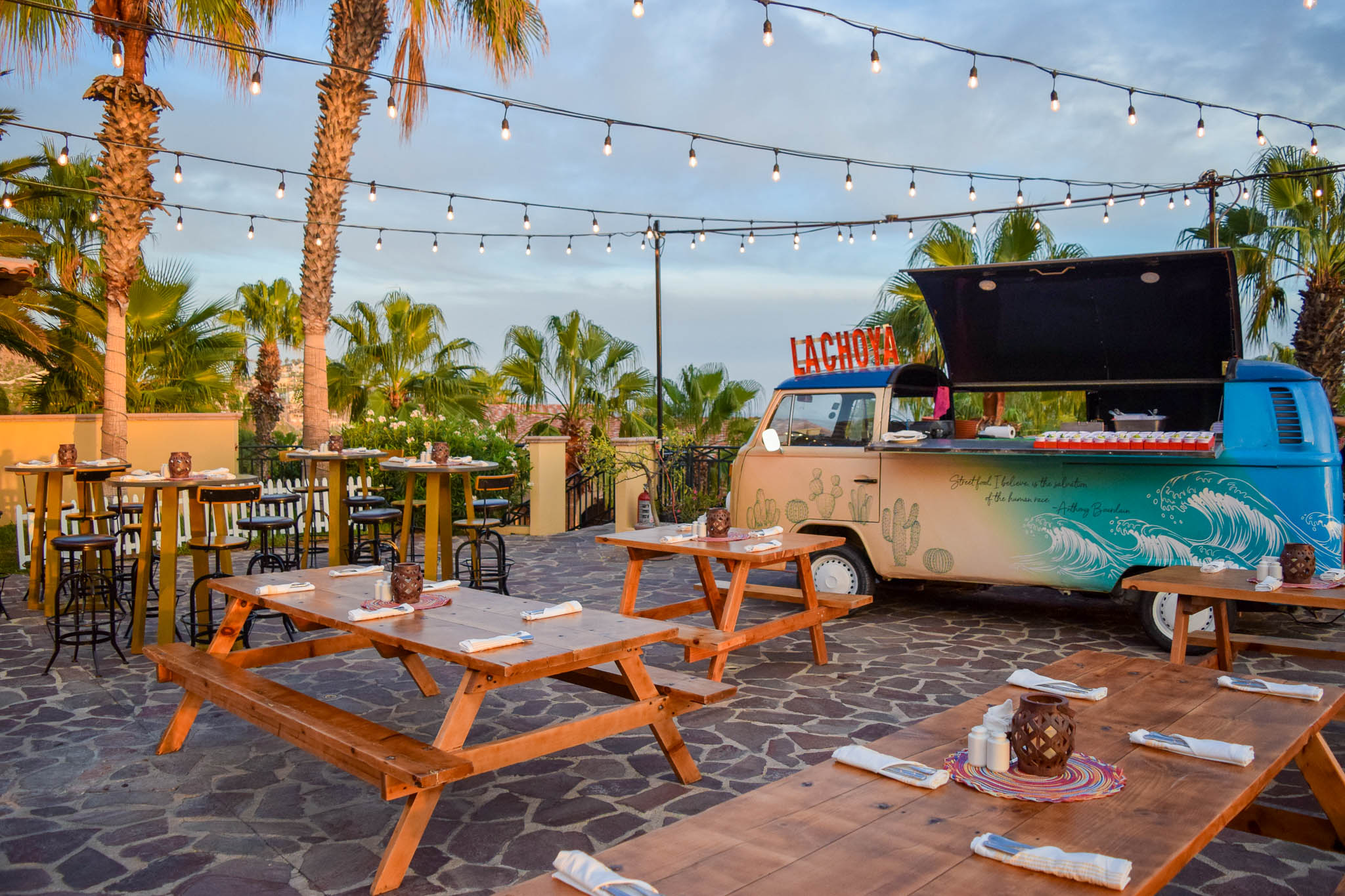 a food truck parked outside with tables and chairs