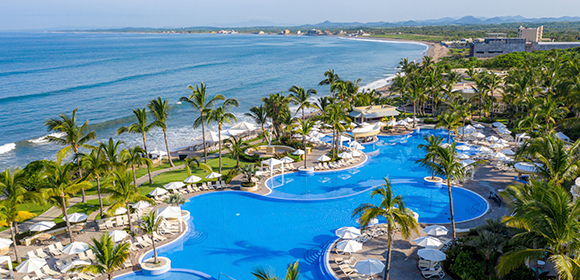 a swimming pool with palm trees and a beach