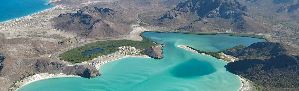 a blue water and mountains