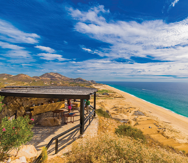 a beach with a wooden structure and a body of water