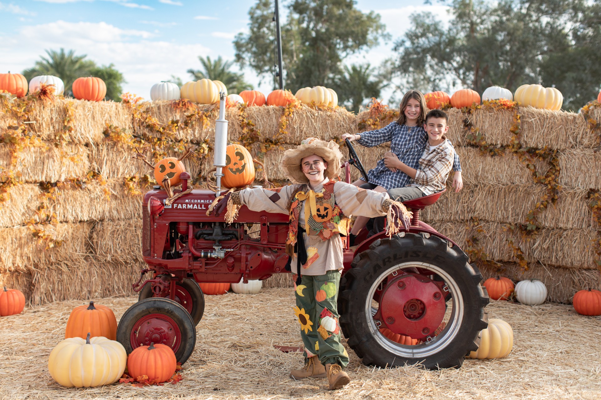 a group of kids posing for a picture in front of a tractor