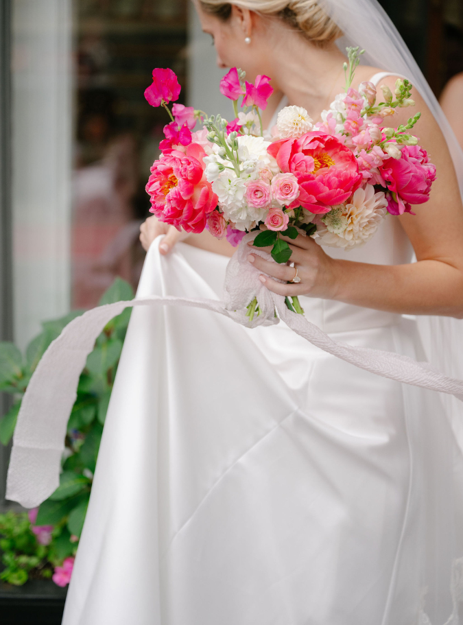 a woman in a white dress holding a bouquet of flowers