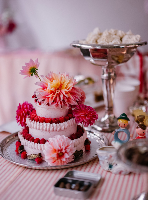 a cake with flowers on top and a bowl of dessert