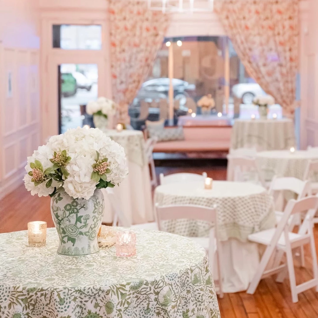 a vase of flowers on a table with tables and chairs
