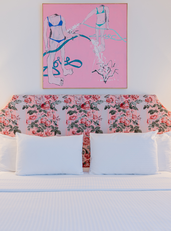 a bed with white sheets and pillows