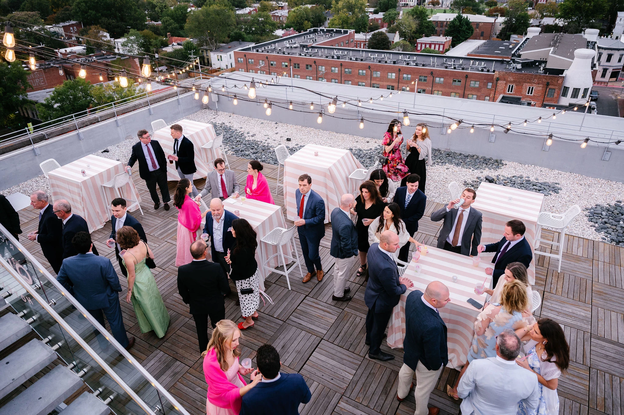 a group of people standing around tables on a rooftop
