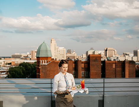 a waitress serving three drinks