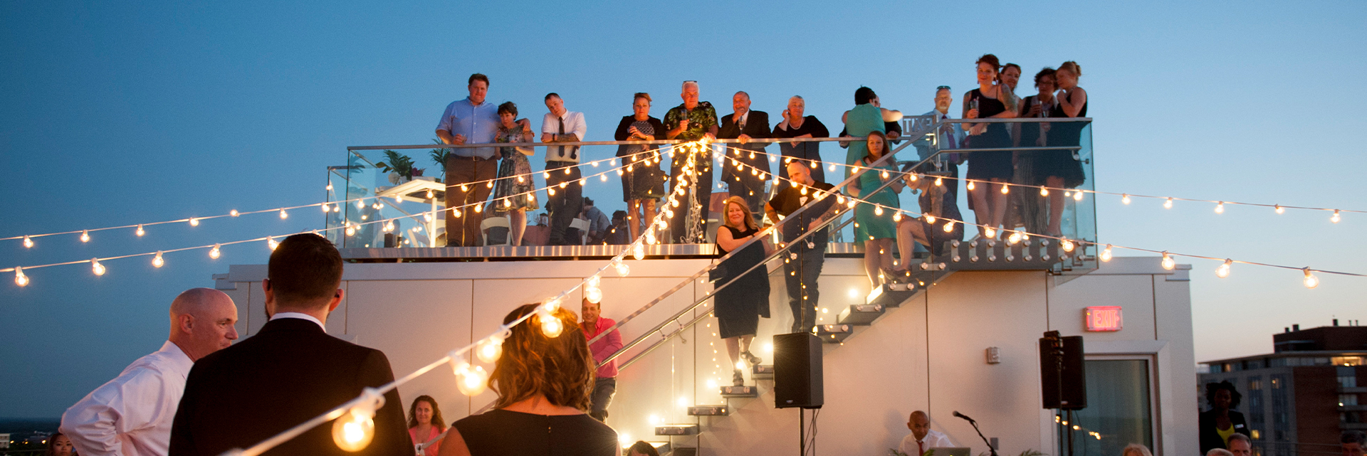 a group of people standing on a staircase with string lights