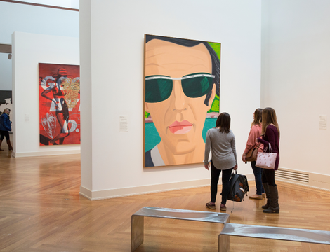 Three women looking at a paintings in an art gallery