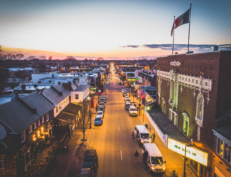 View of a road with parked cars on the side during sunset