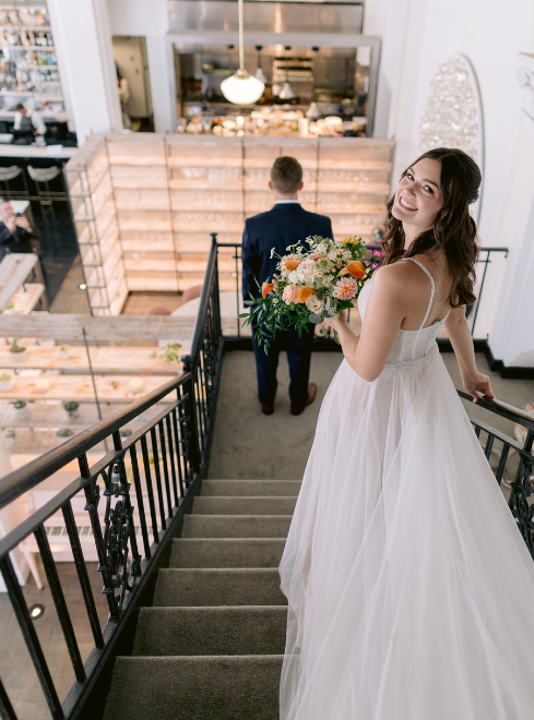 a woman in a white dress holding a bouquet of flowers
